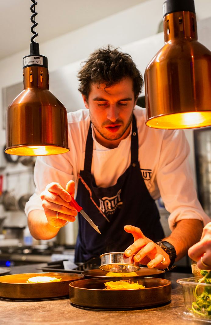 Chef plating dishes in a busy restaurant kitchen
